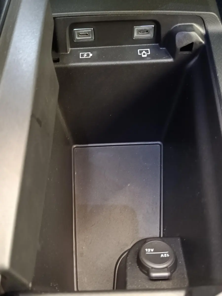 Vue rapprochée de la console centrale du Peugeot 3008 bleu 2025, montrant prises USB et prise 12V.