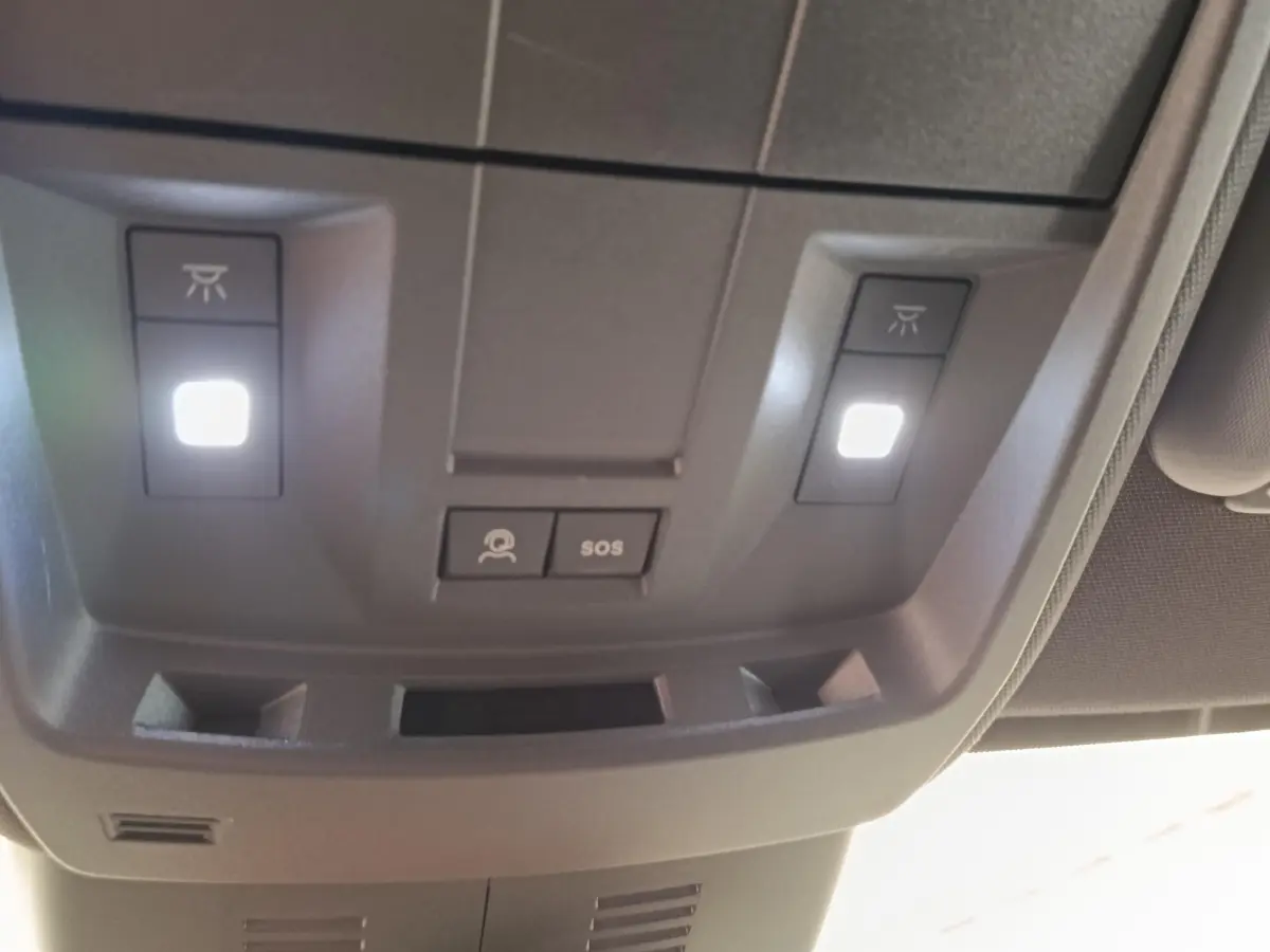 Vue en gros plan du plafonnier gris avec éclairage et boutons SOS du Peugeot 3008 1.2 Hybrid 136 GT 2025.