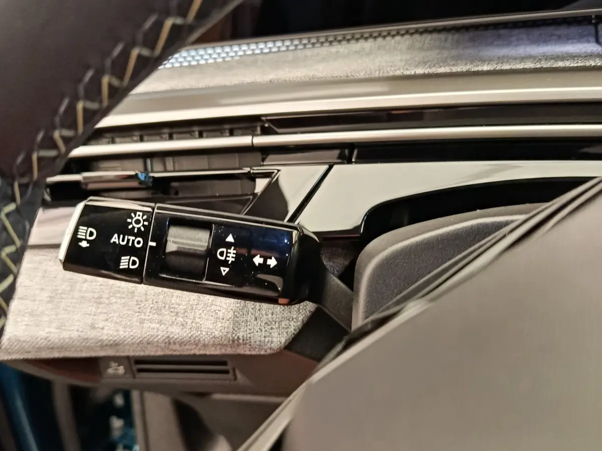 Gros plan sur la commande des feux et clignotants dans l’habitacle du Peugeot 3008 bleu 1.2 HYBRID 136 E-DCS6 GT.