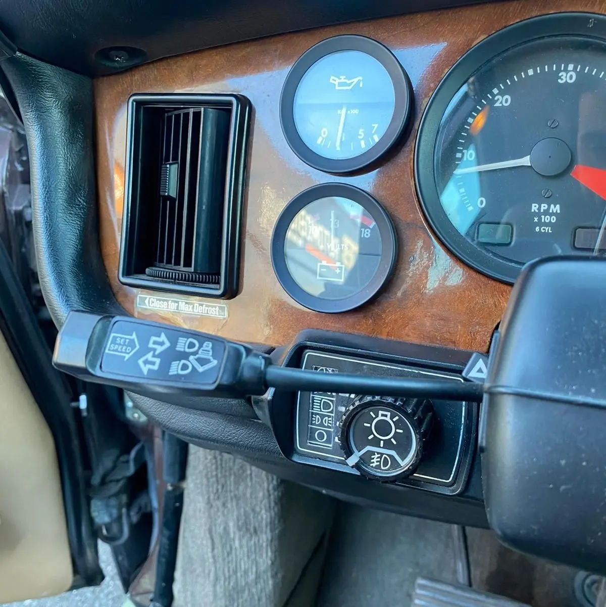 Gros plan sur le tableau de bord en bois marron de la Jaguar XJ6 Série 3 4.2 Sovereign de 1985, côté gauche.