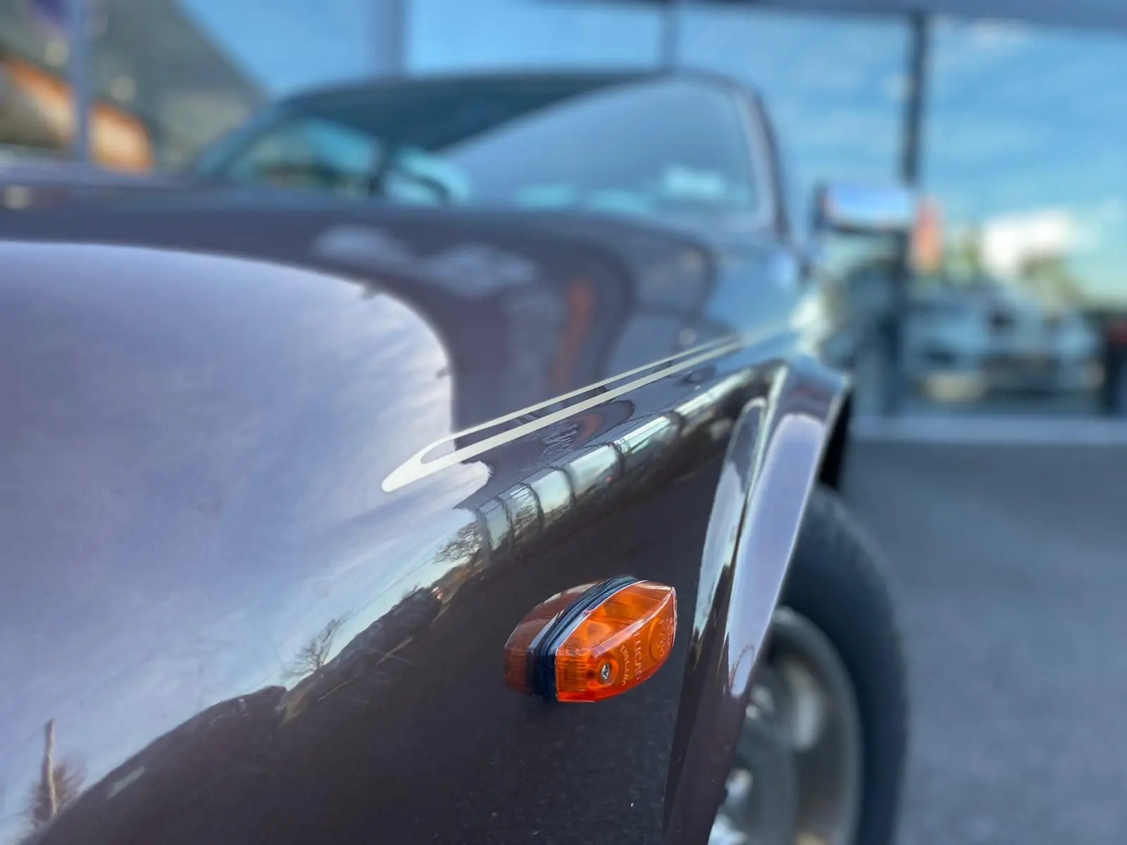 Gros plan sur l'aile avant droite marron d'une Jaguar XJ6 Série 3 4.2 Sovereign 1985 avec clignotant orange.