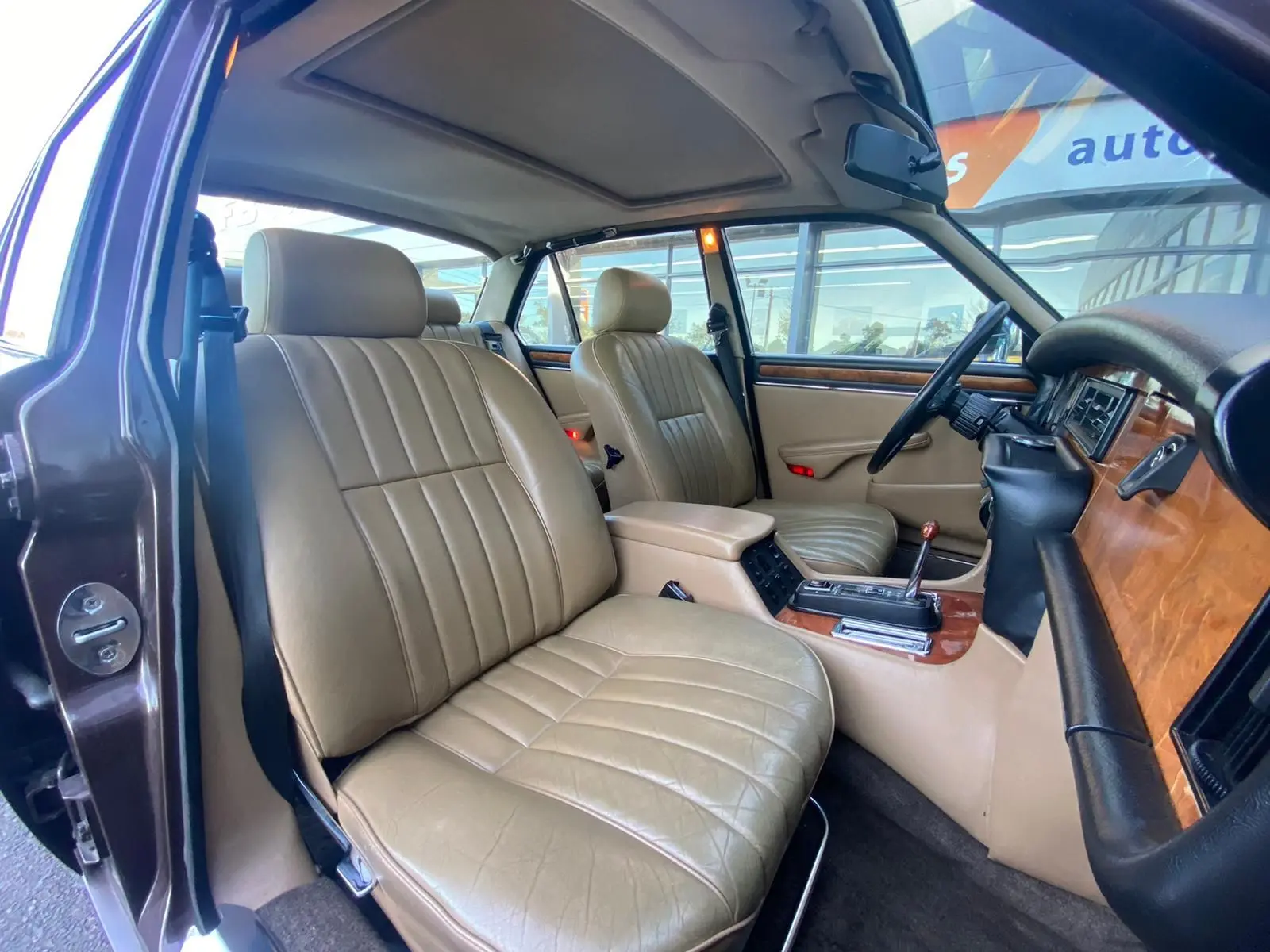 Intérieur beige vue côté gauche de la Jaguar XJ6 Série 3 4.2 Sovereign 1985 avec boiseries et volant noir.