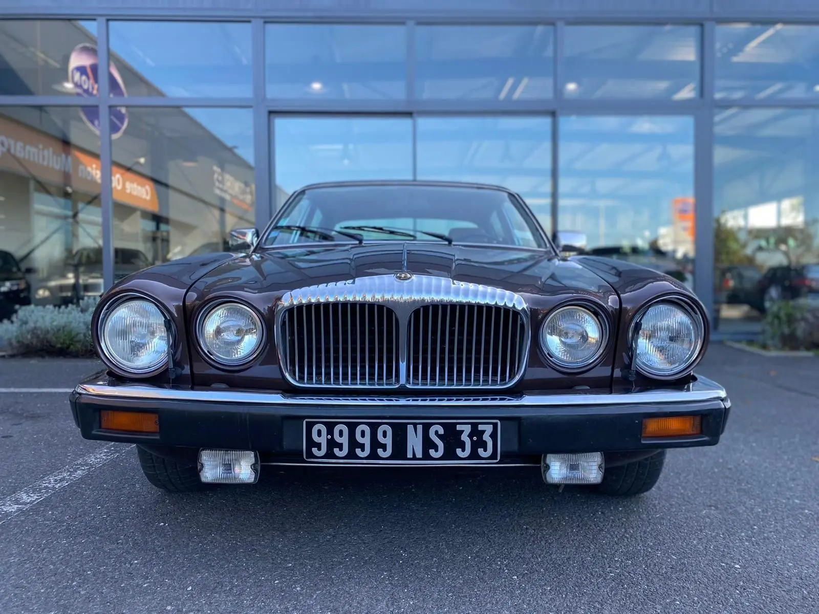 Vue frontale d'une Jaguar XJ6 Série 3 4.2 Sovereign marron de 1985 avec calandre chromée et phares ronds doubles.