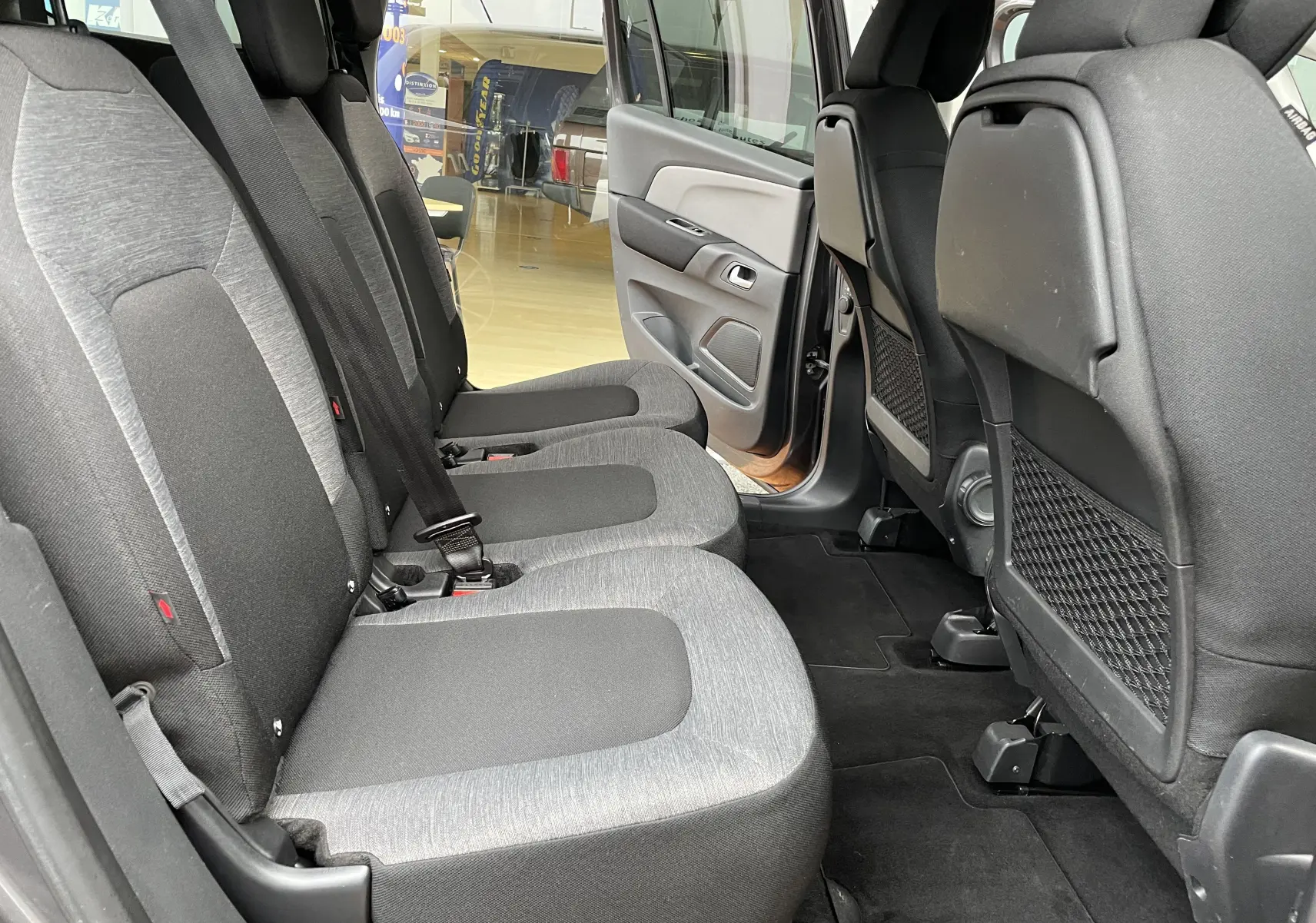Vue latérale des sièges arrière gris clair et foncé du Citroën Grand C4 Picasso 7 places avec porte arrière ouverte.
