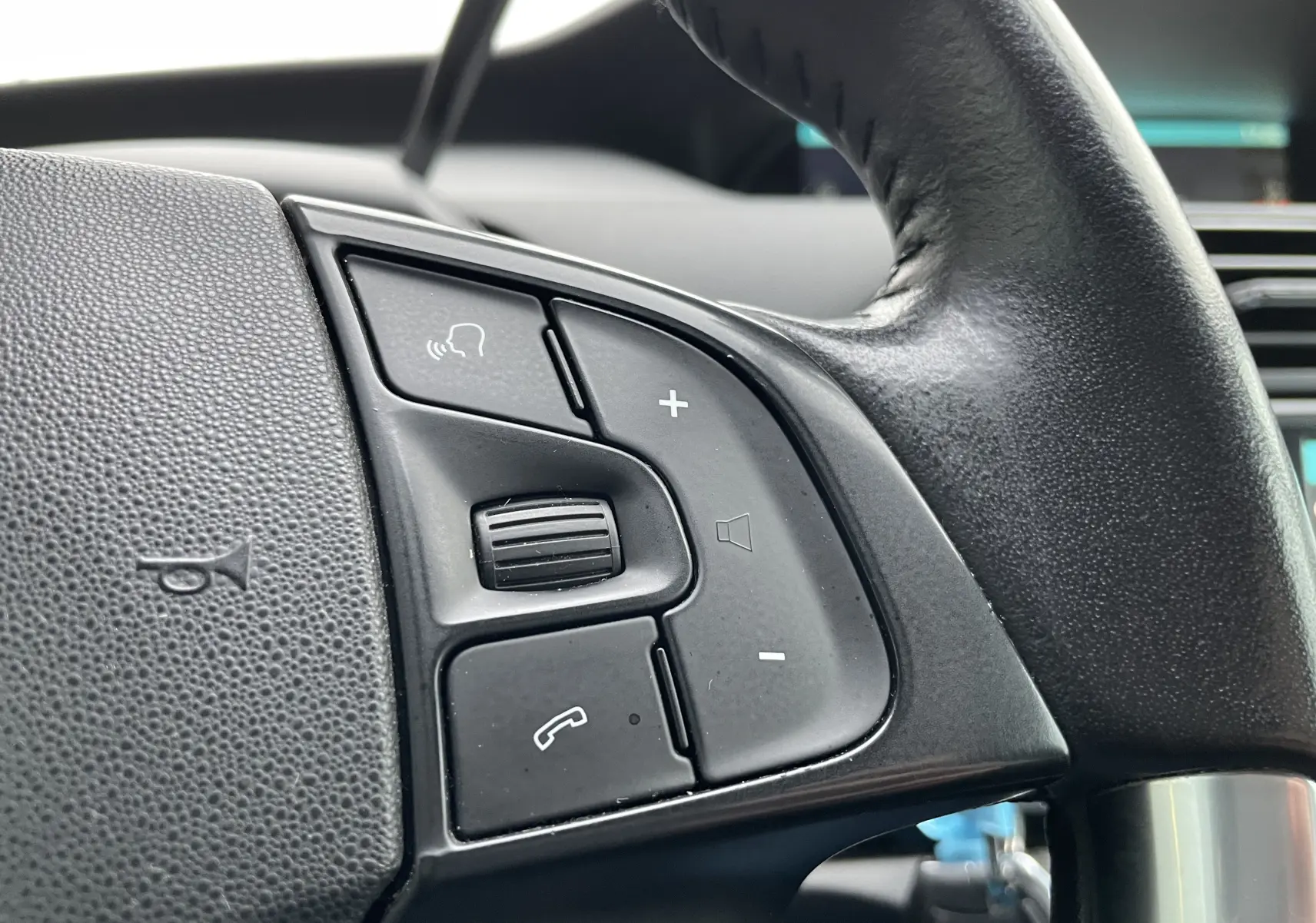 Gros plan sur les commandes audio et téléphone au volant noir du Citroën Grand C4 Picasso gris 2018.