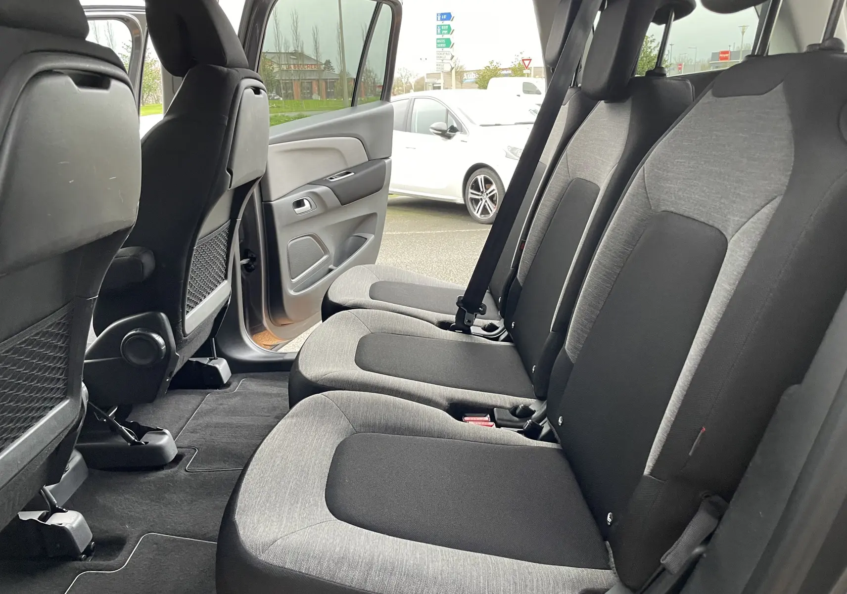 Vue intérieure côté droit sur la banquette arrière grise et noire du Citroën Grand C4 Picasso 2018 avec porte ouverte.