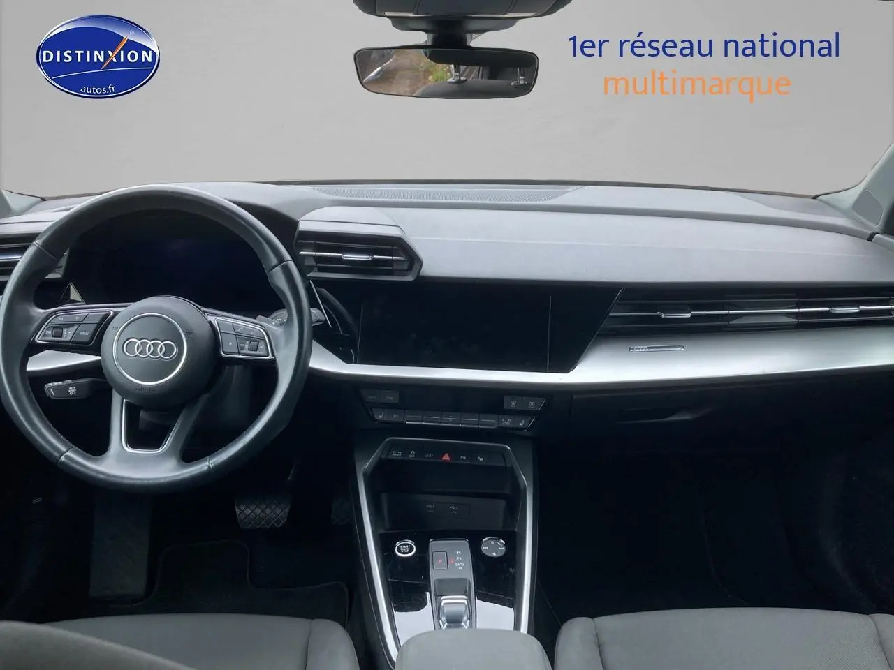 Vue intérieure avant de l'Audi A3 Sportback 40 TFSI noire, mettant en valeur le tableau de bord et le volant multifonction cuir.