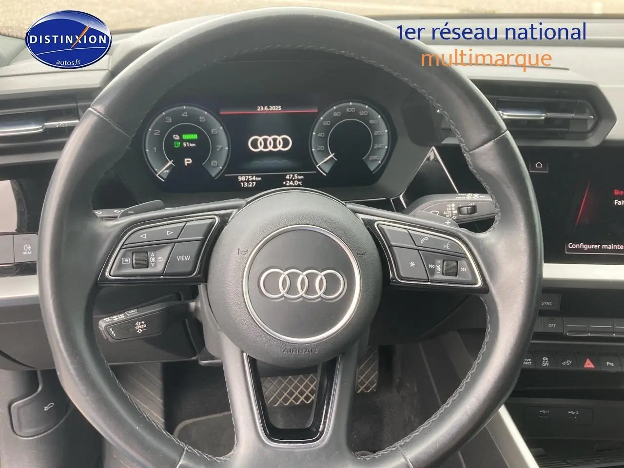 Vue rapprochée du volant cuir multifonction et du tableau de bord numérique d'une Audi A3 Sportback noire 2021.