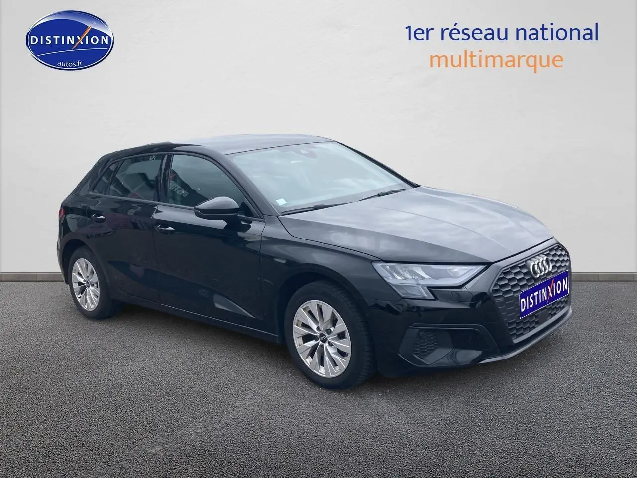 Audi A3 Sportback noir vue en 3/4 avant côté gauche, avec calandre hexagonale et jantes alu visibles.
