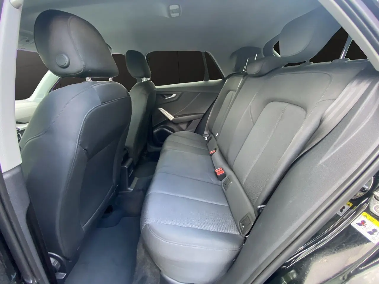 Vue intérieure côté droit des sièges arrière en tissu noir du SUV Audi Q2 noir Mito 2023.