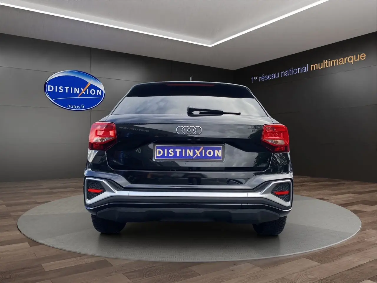 Vue arrière d'un Audi Q2 noir mito 2023 avec hayon motorisé et feux LED dans un showroom.