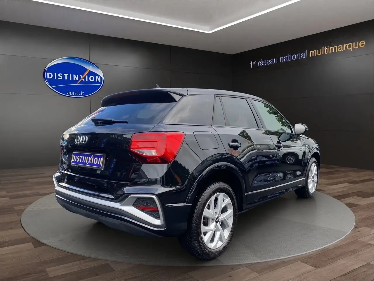 Audi Q2 noir mito vue 3/4 arrière droit, avec jantes alliage 17 pouces et hayon motorisé en showroom.