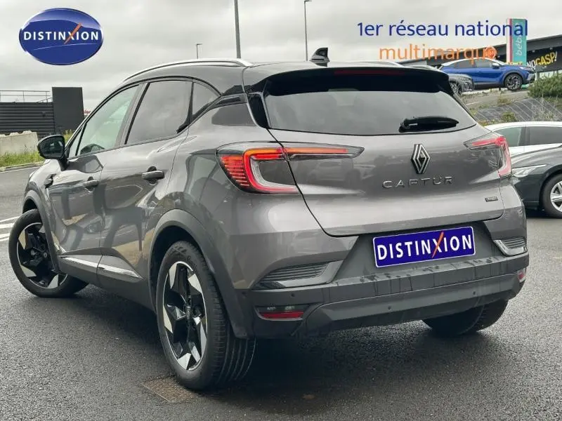 Vue 3/4 arrière droite d'un Renault Captur 2025 noir hybride avec jantes noires et feux arrière LED distinctifs.