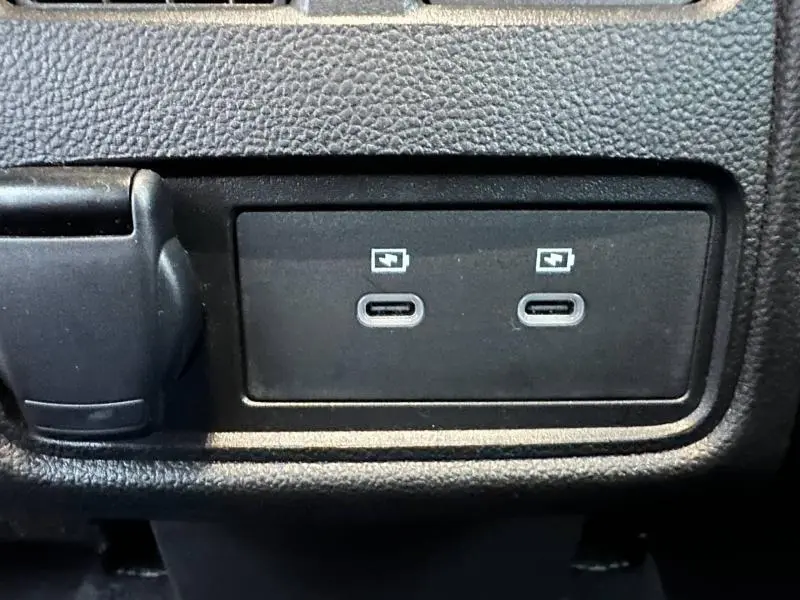 Gros plan sur deux ports USB-C de recharge rapide intégrés dans le tableau de bord noir du Renault Captur 2025.