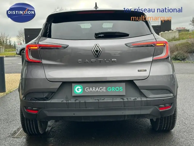 Vue arrière d'un Renault Captur 2025 gris avec feux LED et logo distinctif sur un parking extérieur.