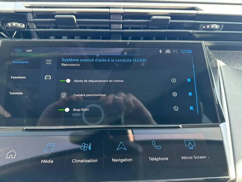 Écran tactile central de la Peugeot 308 2025 affichant les aides à la conduite dans un intérieur moderne noir.