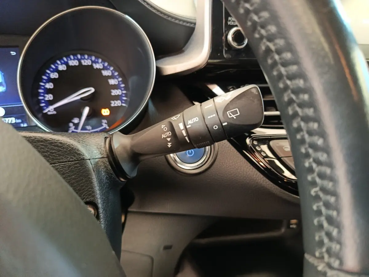 Gros plan sur la commande d’essuie-glace à gauche du volant en cuir noir du Toyota C-HR hybride 2022.