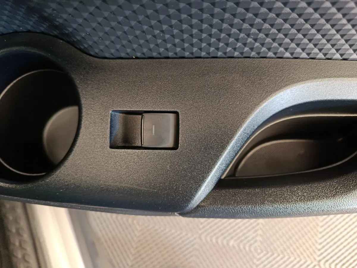 Gros plan sur le bouton de commande de la porte côté conducteur du Toyota C-HR gris clair 2022.