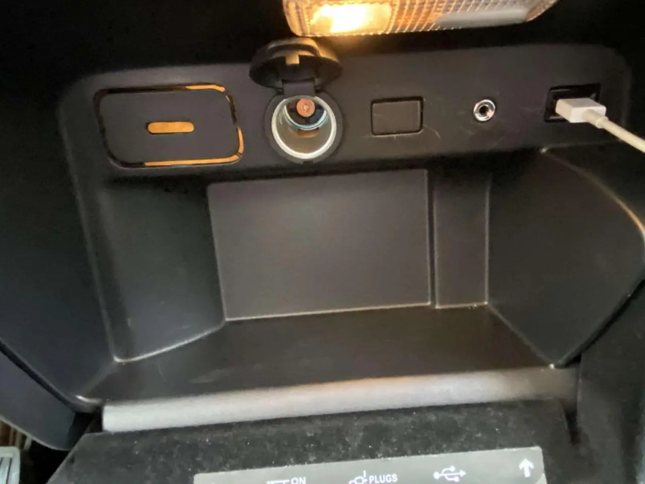 Prise allume-cigare, port jack et port USB dans le rangement central d'une Citroën C4 Spacetourer noire de 2019.