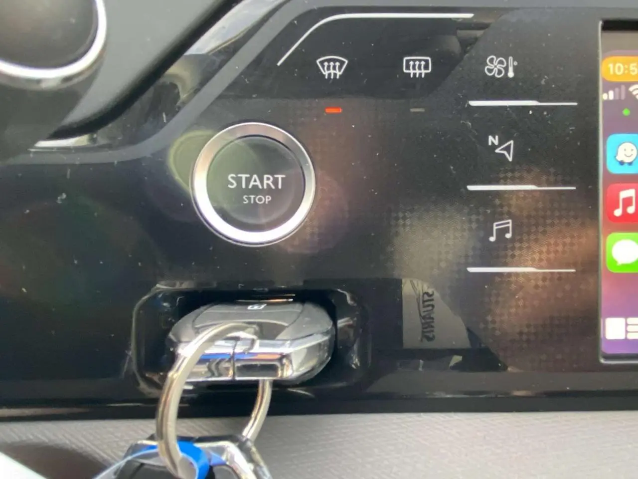 Gros plan sur le tableau de bord noir du Citroën C4 Spacetourer 2019, avec bouton start/stop et clé insérée.