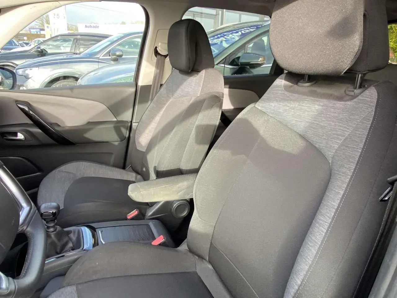 Vue intérieure côté conducteur du Citroën C4 Spacetourer 2019, sièges tissu gris et noir avec accoudoir central.
