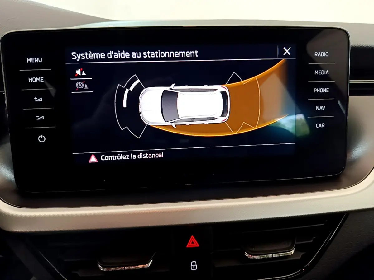 Écran tactile intérieur du Skoda Kamiq 2022 affichant l'aide au stationnement avec alertes de distance