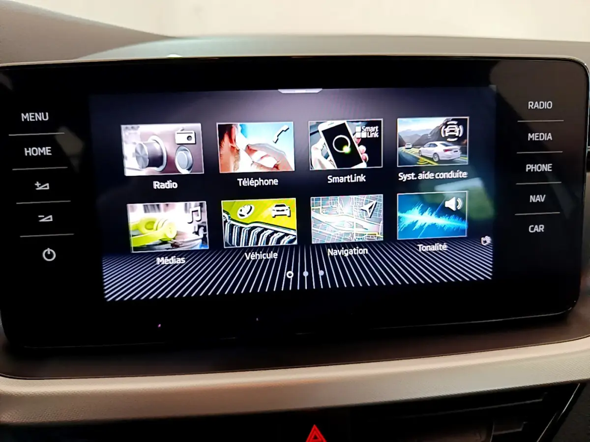 Écran tactile central du tableau de bord d’un Skoda Kamiq gris clair, affichant les options multimédia et navigation.