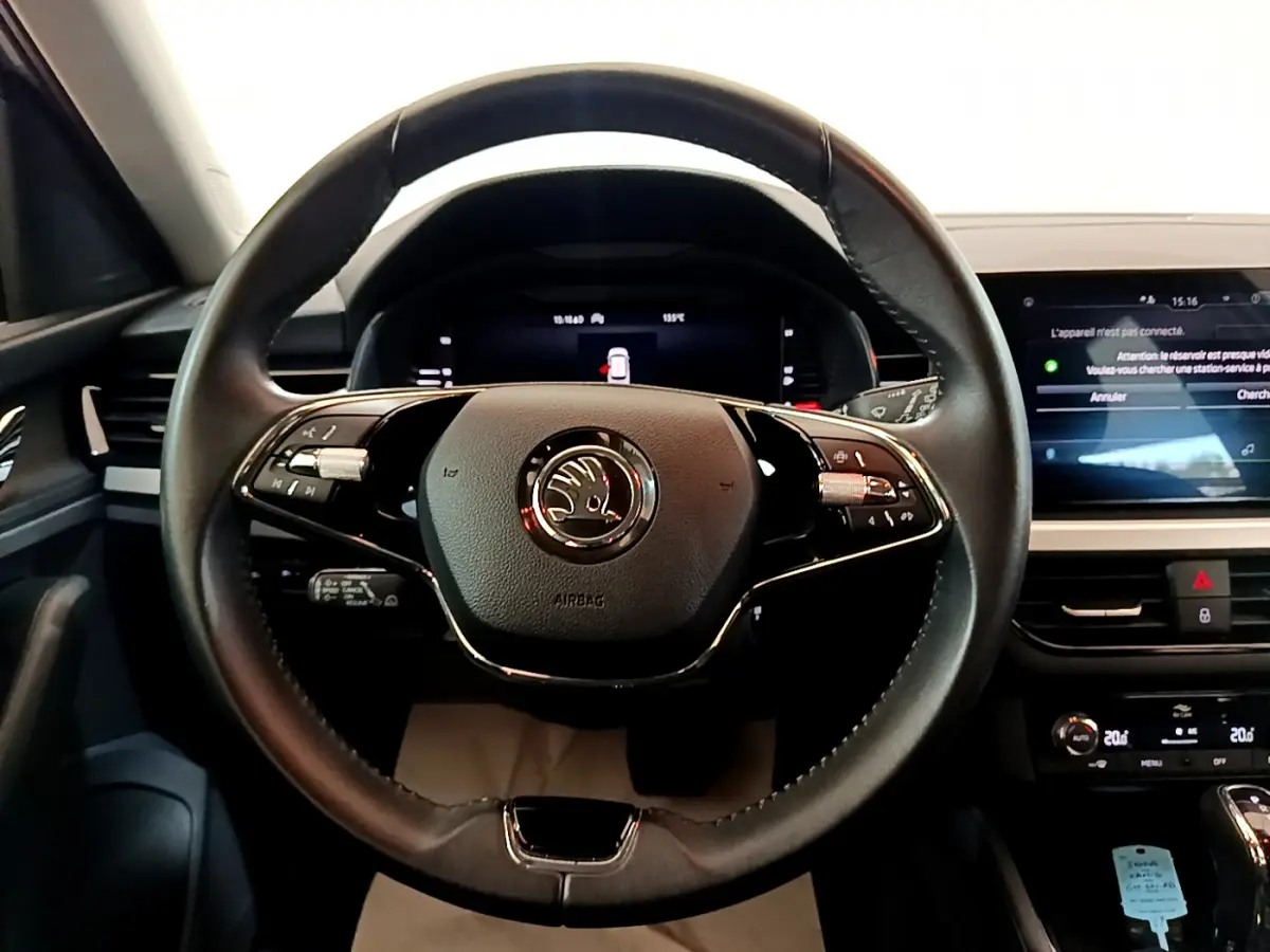 Vue rapprochée du volant cuir noir de la Skoda Kamiq 2022 avec commandes multifonctions et tableau de bord digital.