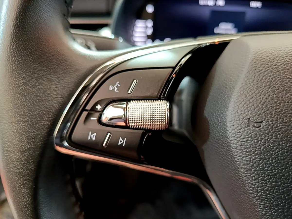 Gros plan sur les commandes gauche du volant cuir du Skoda Kamiq 2022, boutons de volume et voix intégrée.