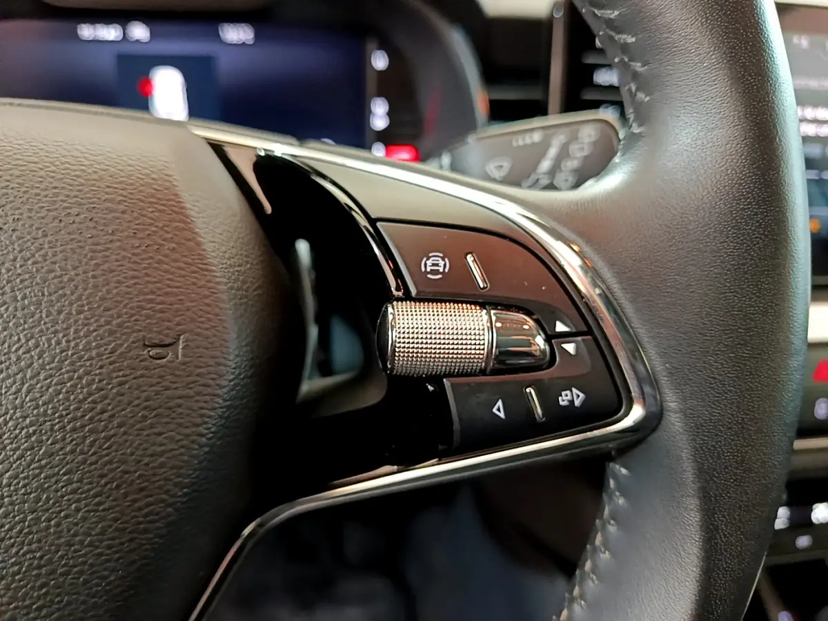 Gros plan sur les commandes multifonctions côté gauche du volant cuir du Skoda Kamiq gris clair 2022.
