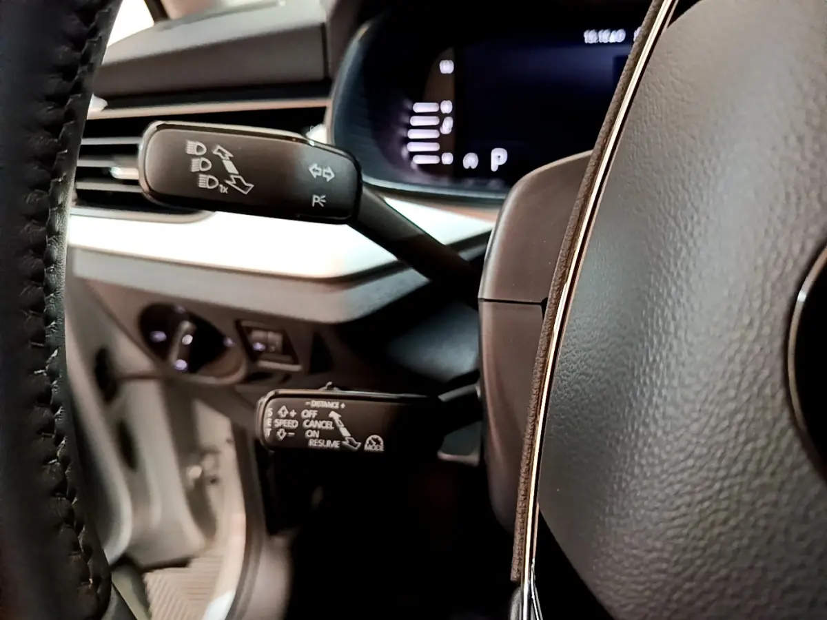 Détail des commandes au volant d'une Skoda Kamiq 2022, vue rapprochée côté gauche avec tableau de bord numérique.