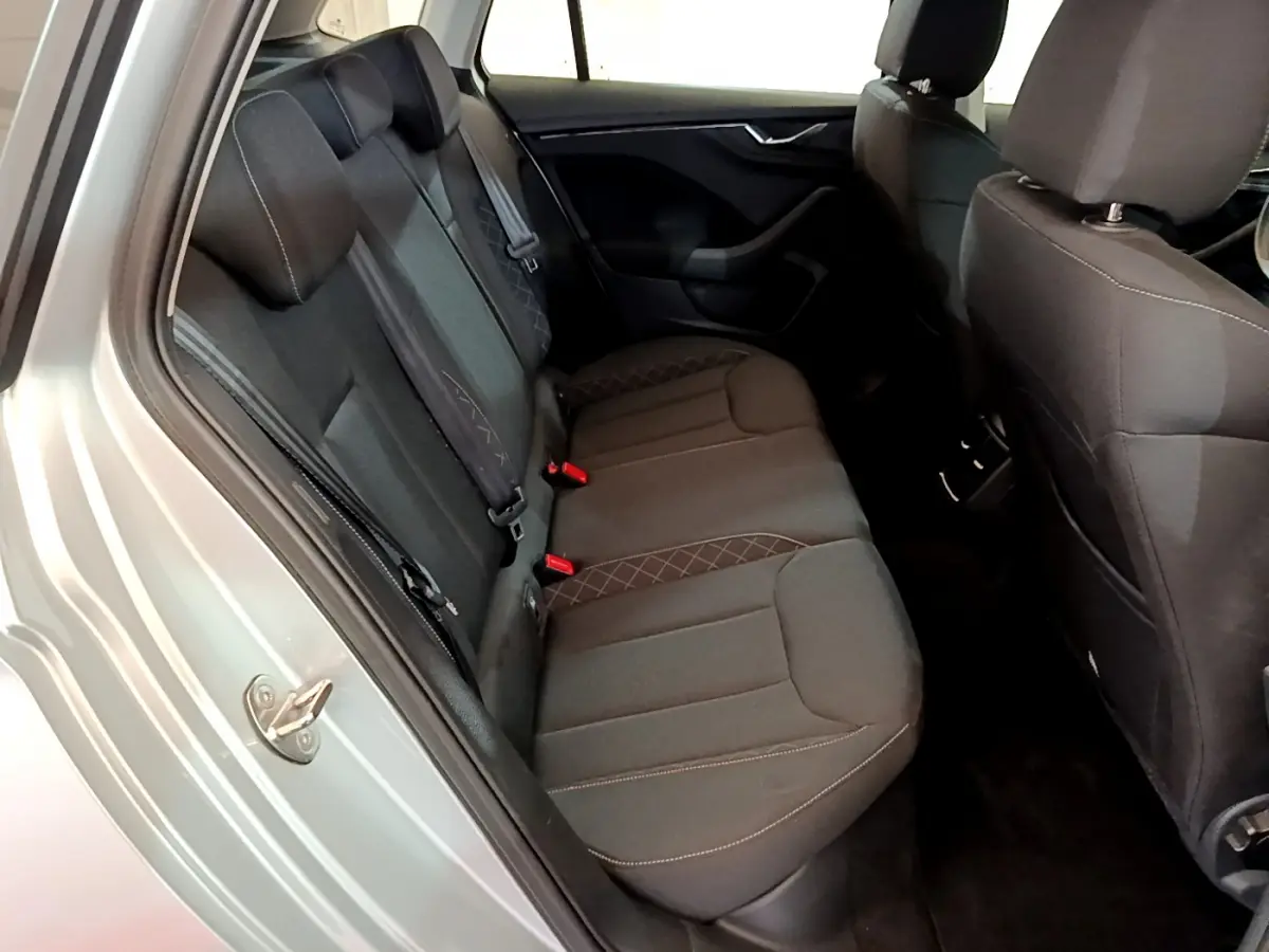 Vue intérieure arrière côté gauche du Skoda Kamiq gris clair 2022, sièges tissu noir avec surpiqûres contrastées.