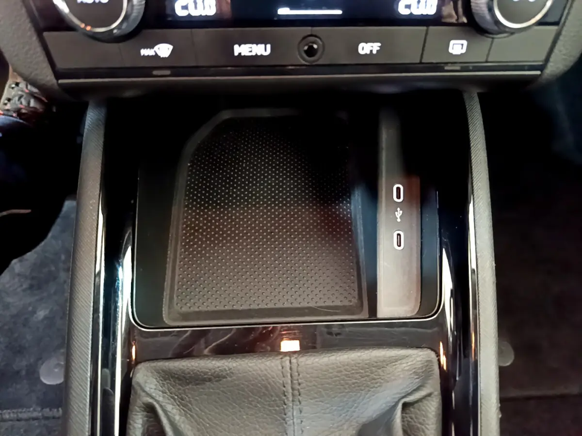 Gros plan sur la console centrale du Skoda Kamiq 2022, avec zone de recharge sans fil et ports USB visibles.