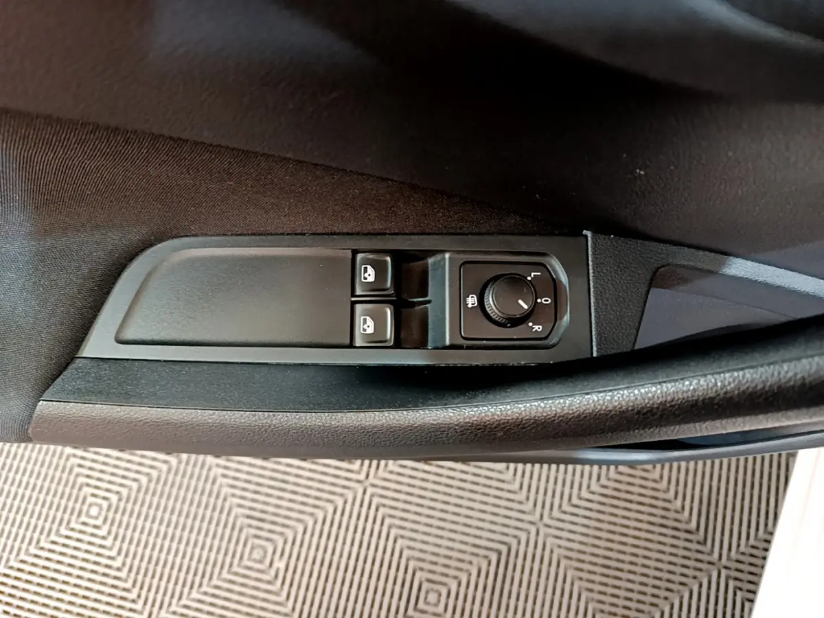 Commandes des vitres et réglage des rétroviseurs sur la porte côté conducteur d'un Skoda Kamiq gris clair 2022