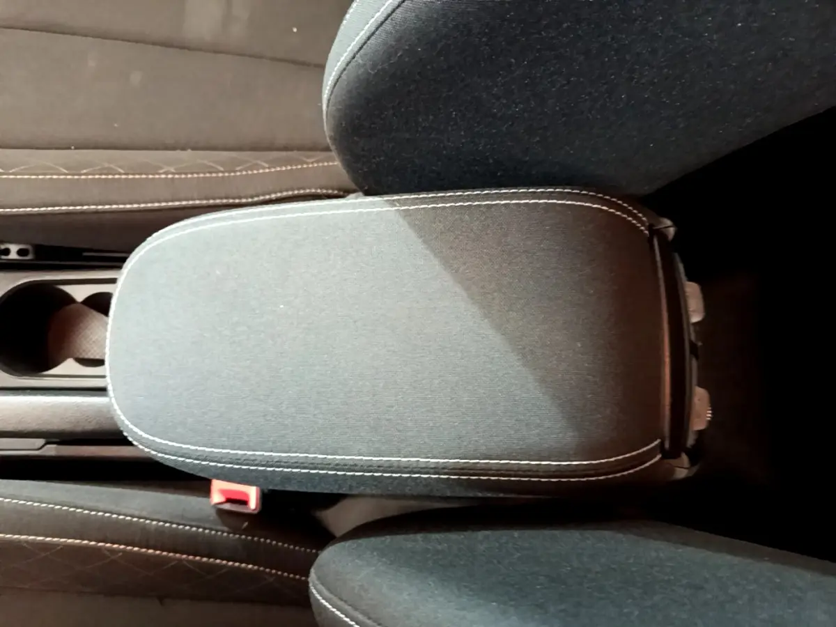 Vue rapprochée de l'accoudoir central noir avec surpiqûres blanches dans l'habitacle du Skoda Kamiq gris clair 2022.