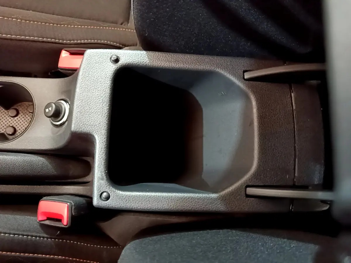 Vue rapprochée de la console centrale noire du Skoda Kamiq 2022 avec porte-gobelet et bouton 12V visible.