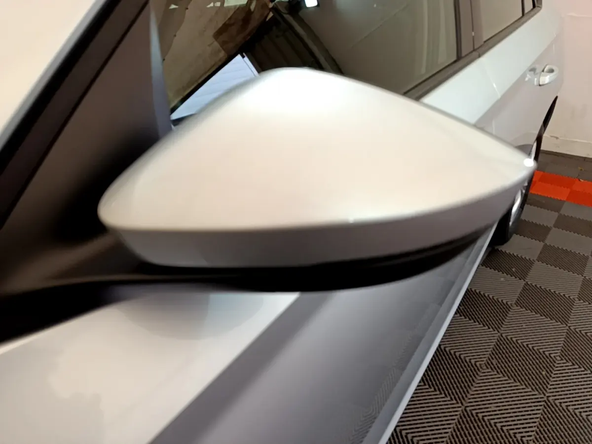 Gros plan sur le rétroviseur droit gris clair du Skoda Kamiq 2022, avec la portière et une partie de la roue visibles.