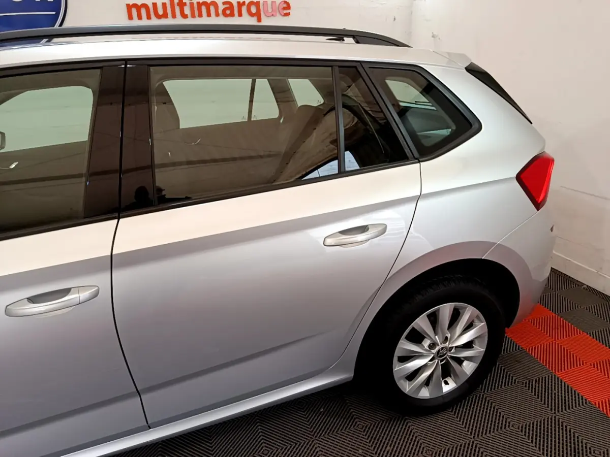 Vue latérale côté droit du Skoda Kamiq gris clair 2022, mettant en valeur la porte arrière et la roue arrière.