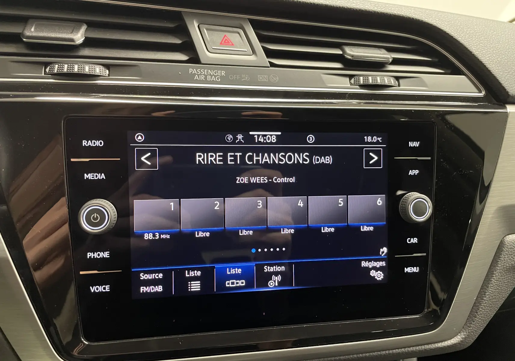 Écran tactile central du tableau de bord du Volkswagen Touran 2024 affichant la radio numérique Rire et Chansons.