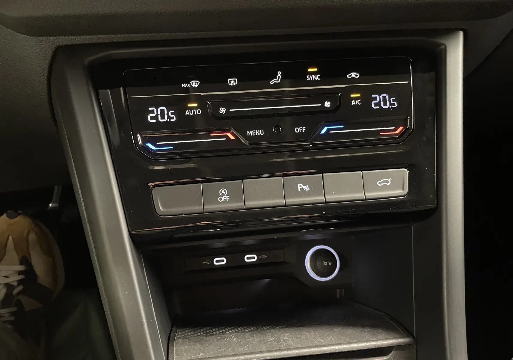 Vue rapprochée de la console centrale du Volkswagen Touran 2024 avec climatisation digitale et commandes de hayon électrique.