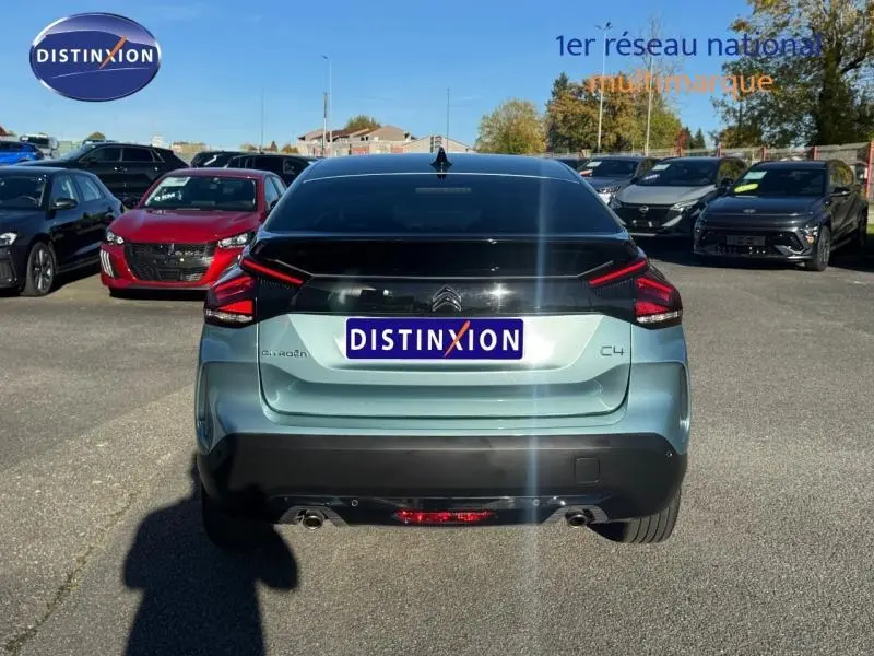 Vue arrière d'une Citroën C4 gris 2024 avec feux LED distinctifs et toit noir brillant sur parking extérieur.