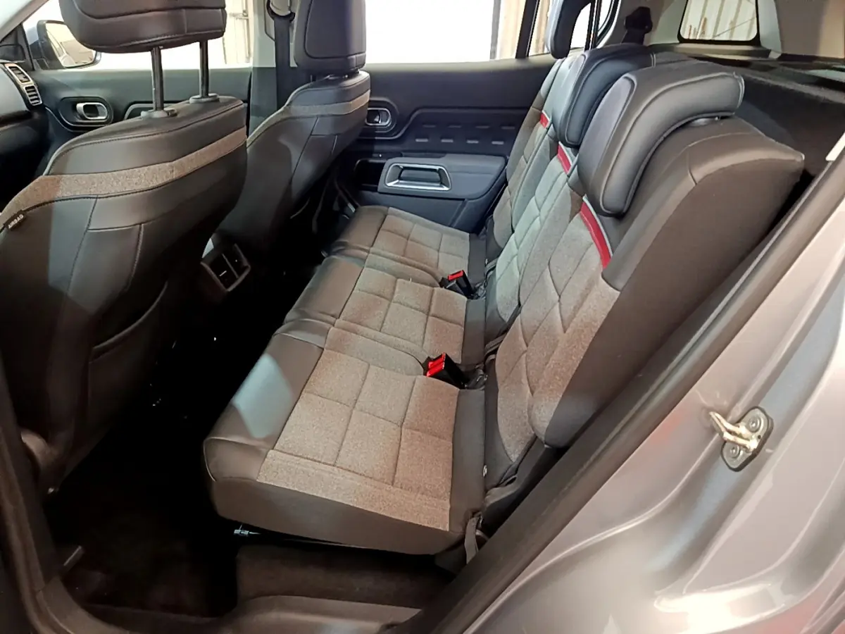 Vue côté droit sur les sièges arrière gris tissu et cuir du Citroën C5 Aircross Hybrid 225 ë-EAT8 Business, intérieur spacieux.