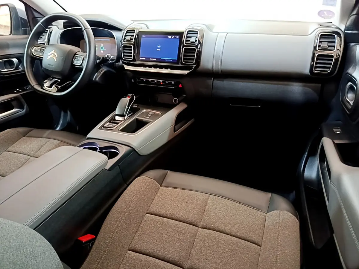 Intérieur du Citroën C5 Aircross Hybrid 225 Business, vue côté passager, tableau de bord gris clair avec écran tactile central.