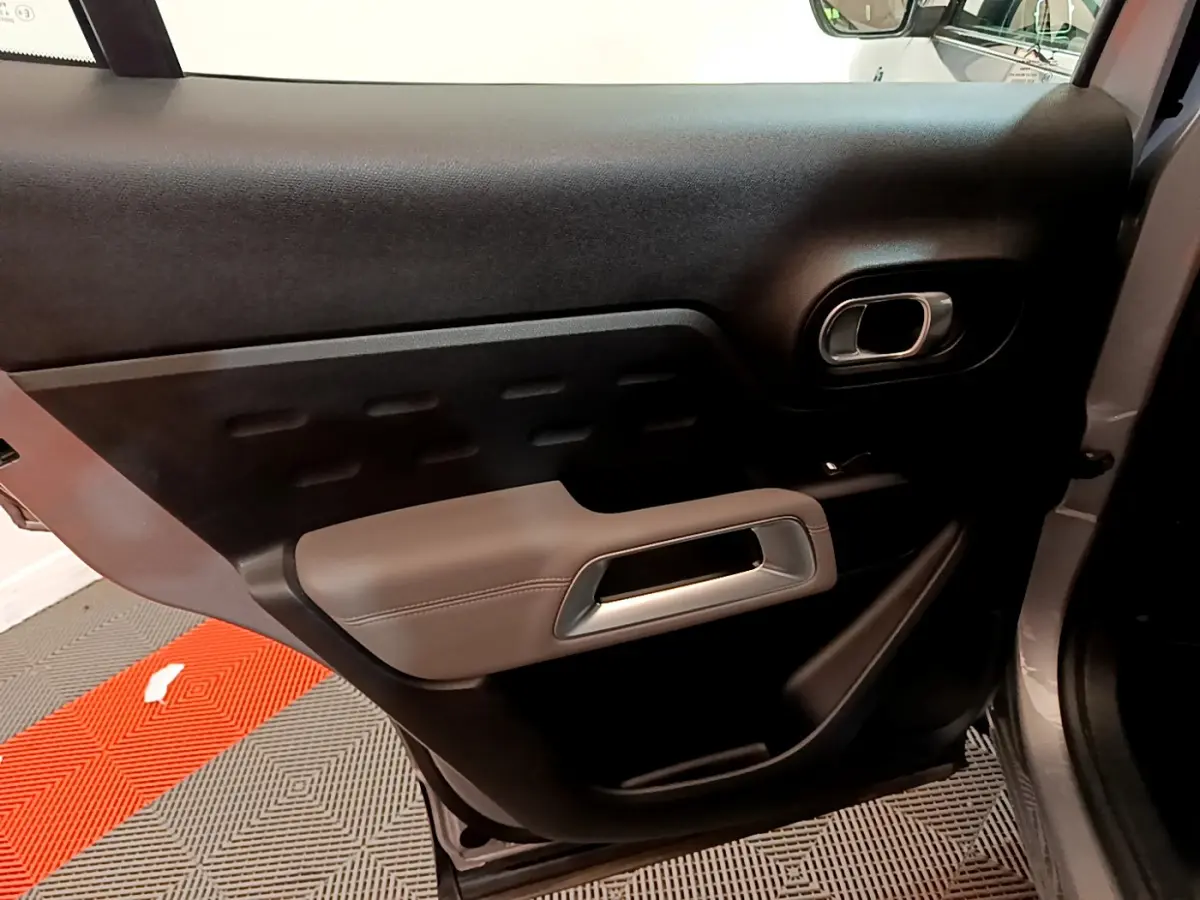 Gros plan sur la porte arrière droite gris clair du Citroën C5 Aircross Hybrid avec poignée argentée et garniture noire.