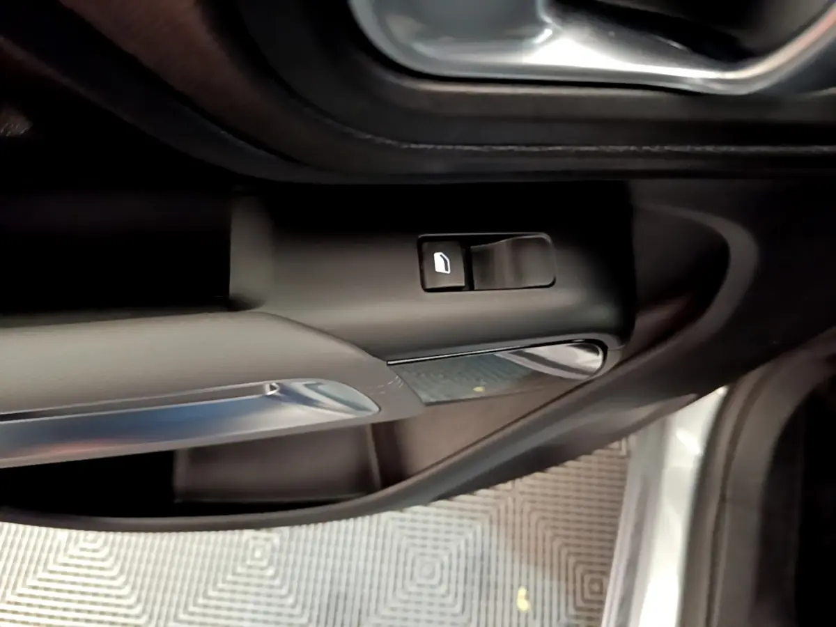 Détail de la commande d'ouverture de porte côté conducteur d'une Citroën C5 Aircross Hybrid gris clair de 2021.