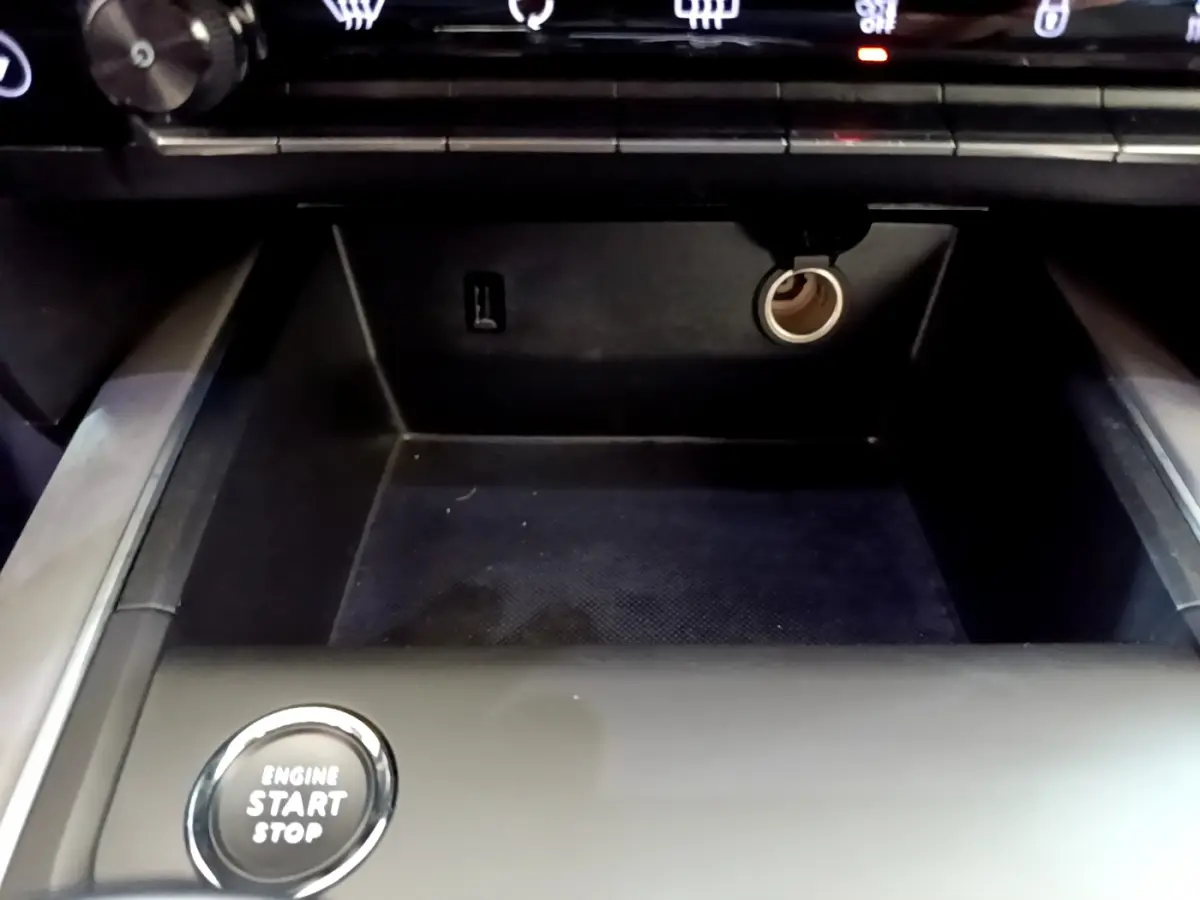 Gros plan sur la console centrale noire du Citroën C5 Aircross Hybrid avec bouton démarrage et prise 12V visible