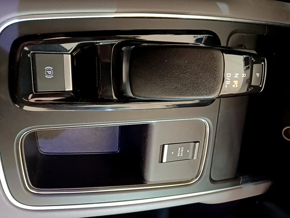 Gros plan sur la console centrale noire du Citroën C5 Aircross Hybrid 225 ë-EAT8 avec levier de vitesses automatique et bouton Drive Mode.