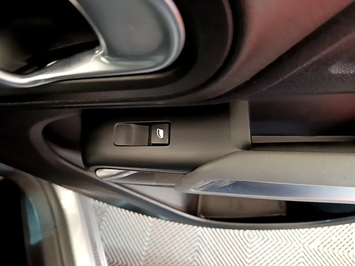 Détail de la commande de lève-vitre côté conducteur dans l'habitacle gris clair du Citroën C5 Aircross Hybrid 225 ë-EAT8 Business.