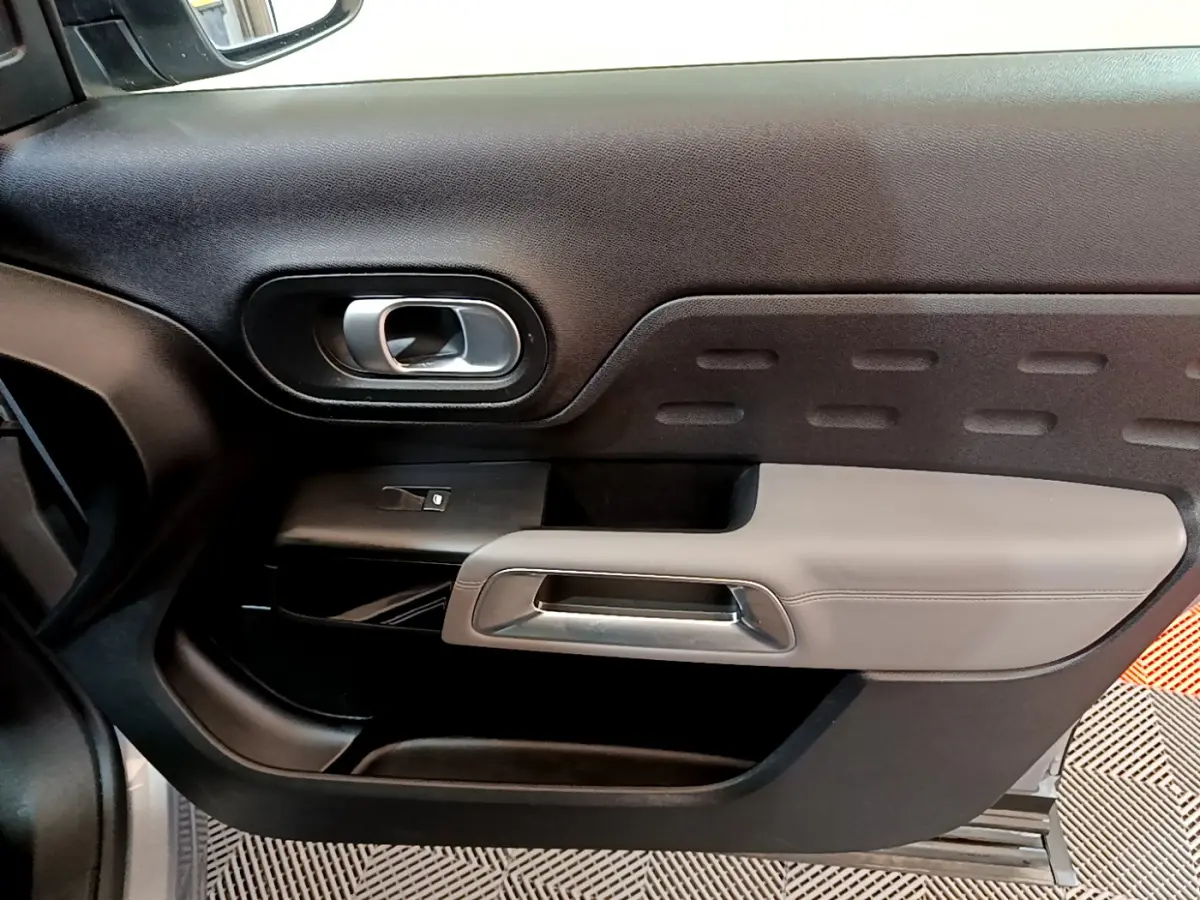 Détail de la porte côté gauche du Citroën C5 Aircross Hybrid 225 ë-EAT8 Business 2021 en gris clair, intérieur noir et gris.