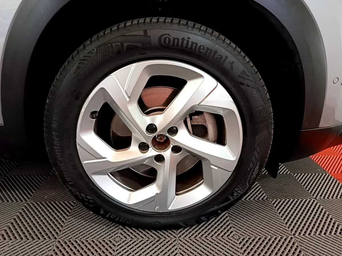 Gros plan sur la roue avant droite du Citroën C5 Aircross Hybrid gris clair, avec jante en alliage et pneu Continental.